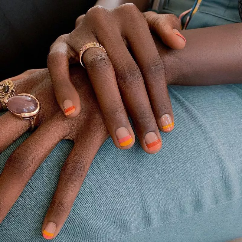 Negative space nails with double-layered orange tips