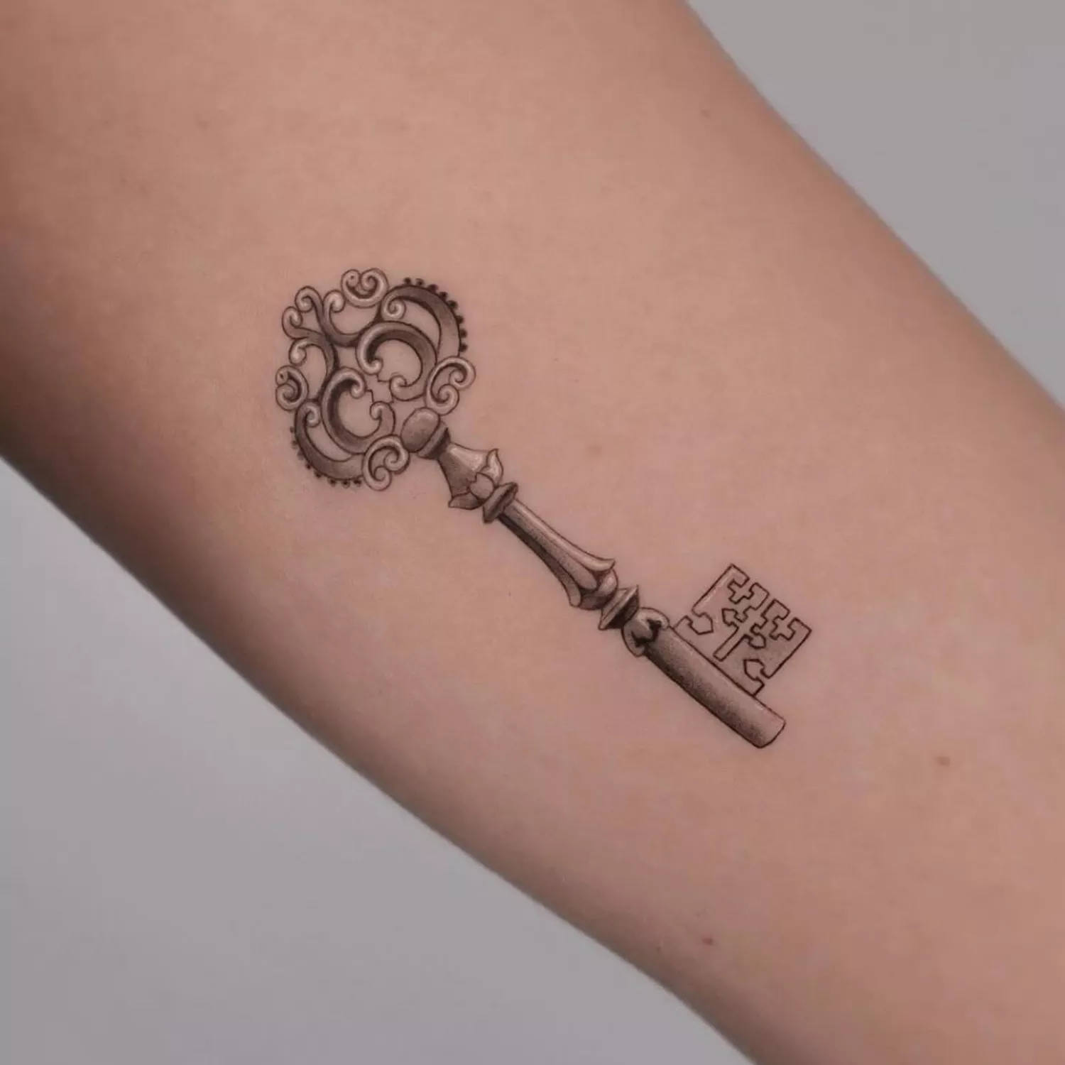 skeleton key tattoo on inner forearm