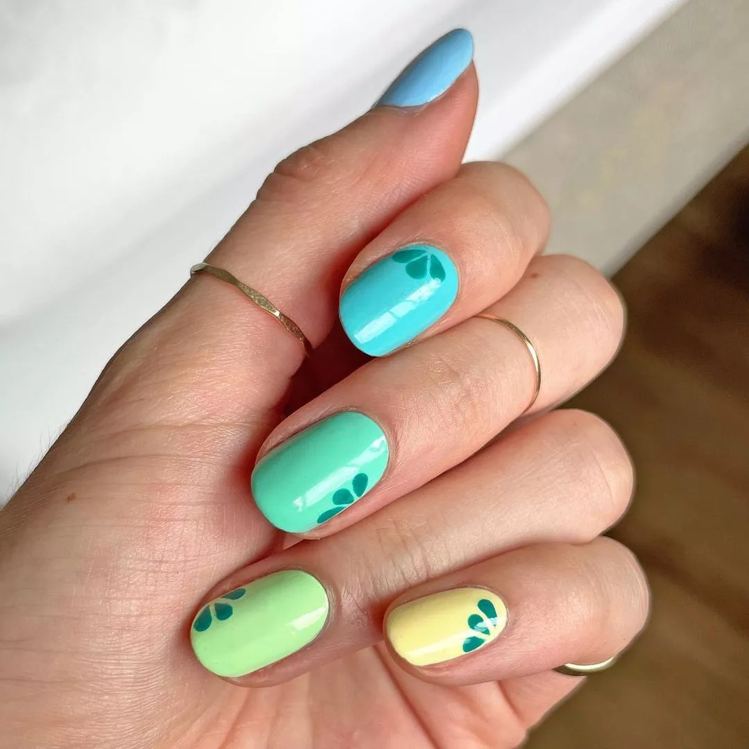 Blue gradient manicure with flowers at the base of each nail