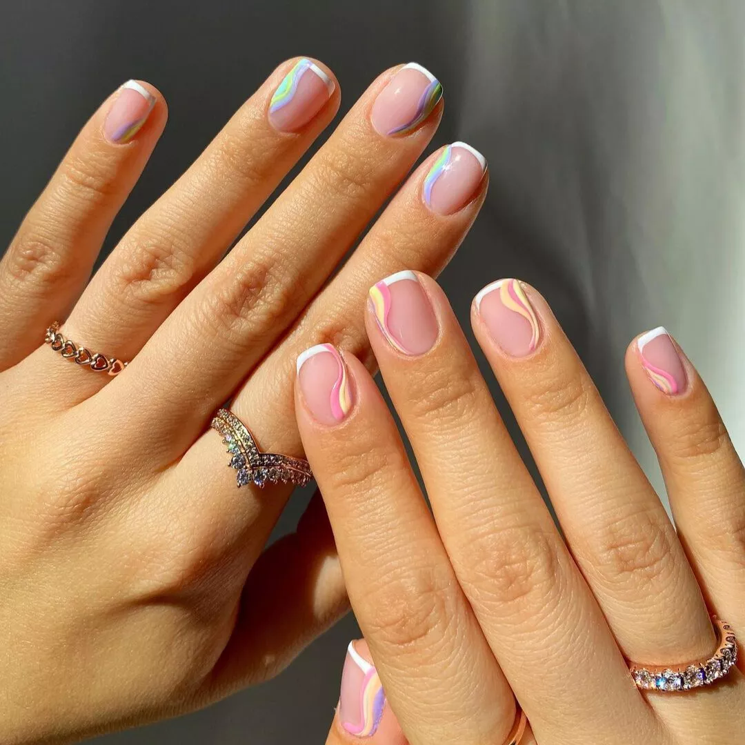 short french tips on natural nails with pastel swirl designs