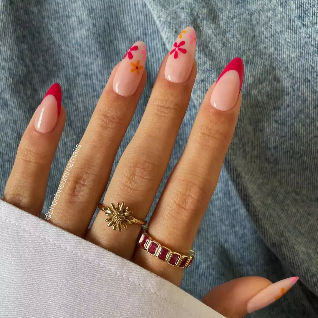 Fuchsia pink french tips with flowers at the tips on two accent nails that use pink and orange