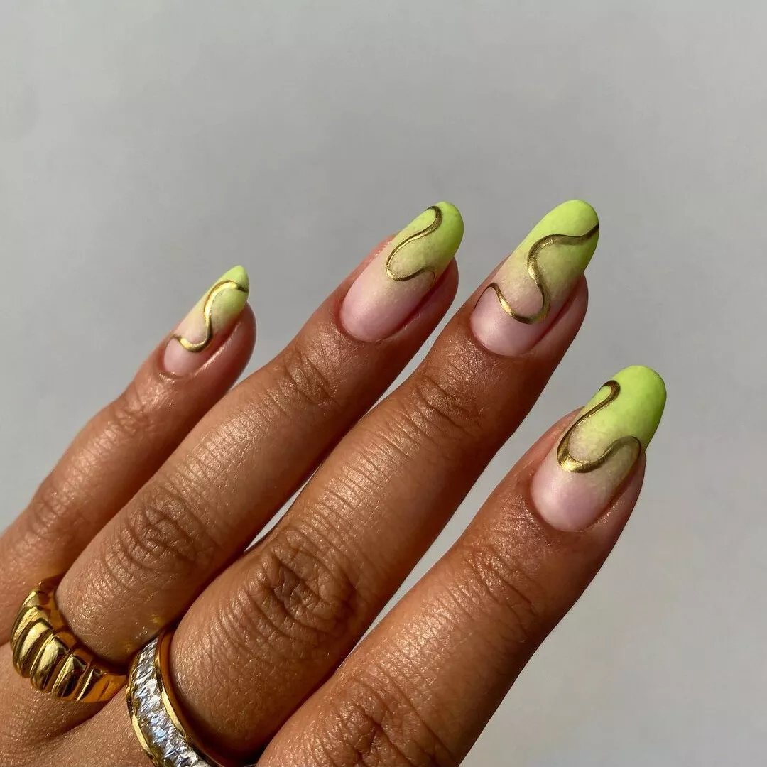 Ombre pastel green oval shaped nails with gold chrome swirls
