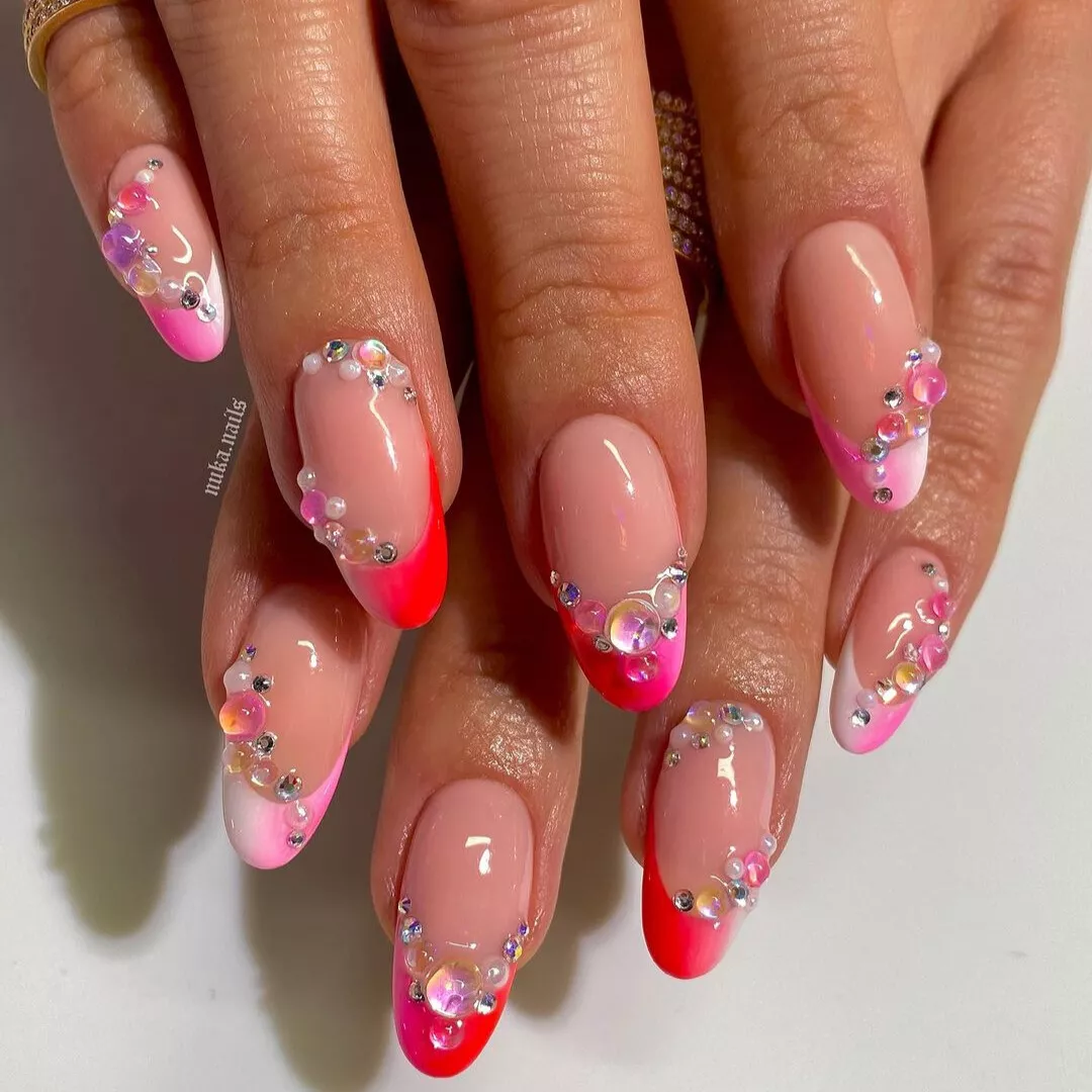 Ombre pink white and orange nails with bedazzled pearly jewels