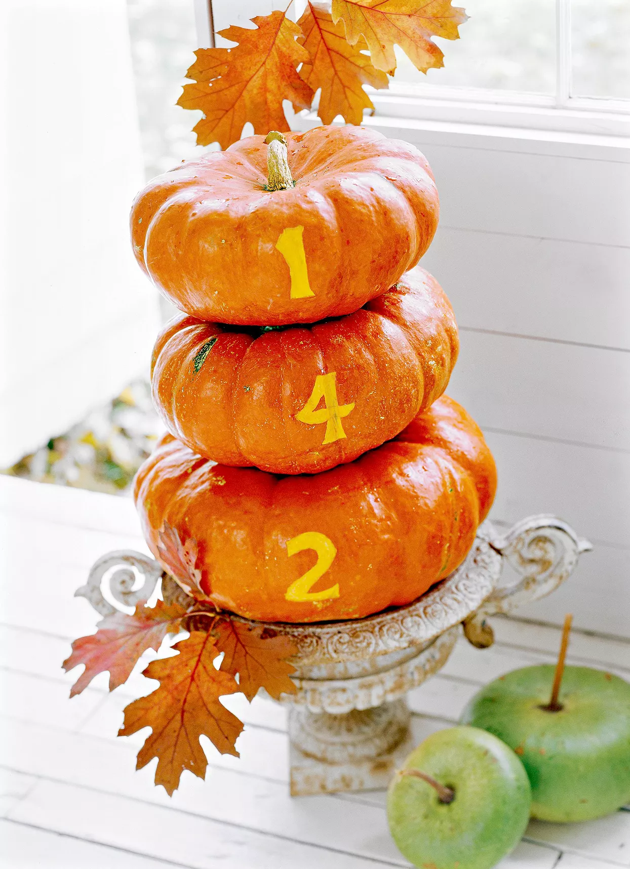 Outdoor stacked pumpkins that have the numbers "142"