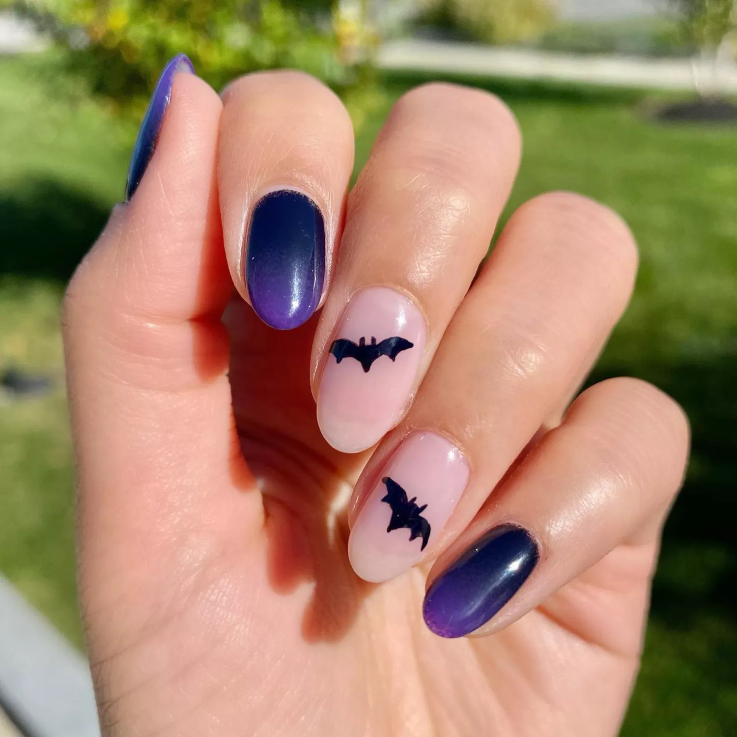 Oval nails with purple ombre shade and small hand painted bats. 