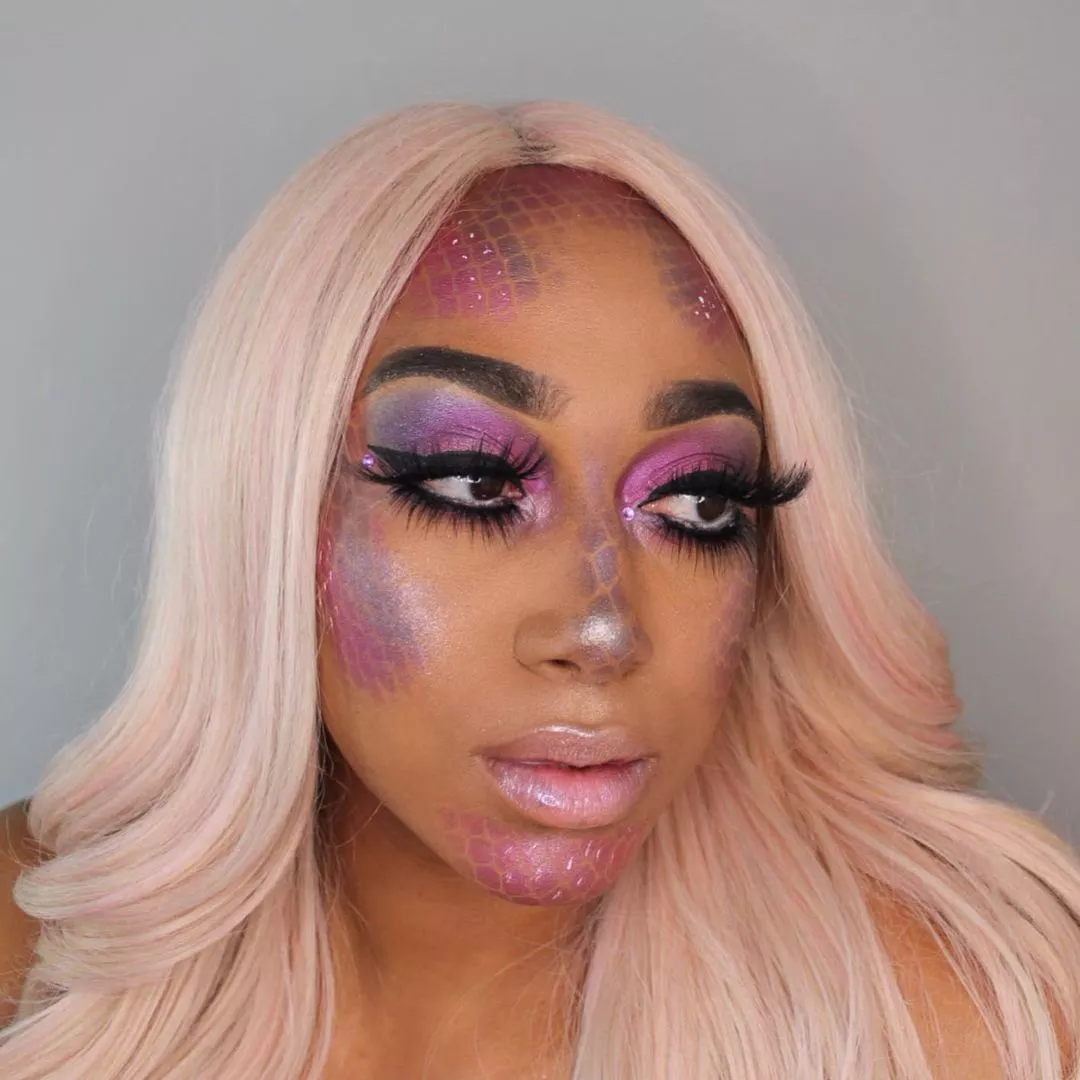 Makeup artist wears pink wig and mermaid-inspired makeup look with scales