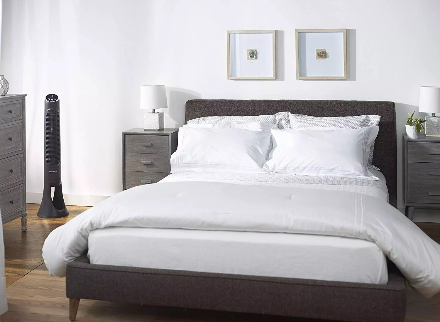 A neutral tone bedroom with a tower fan in the corner