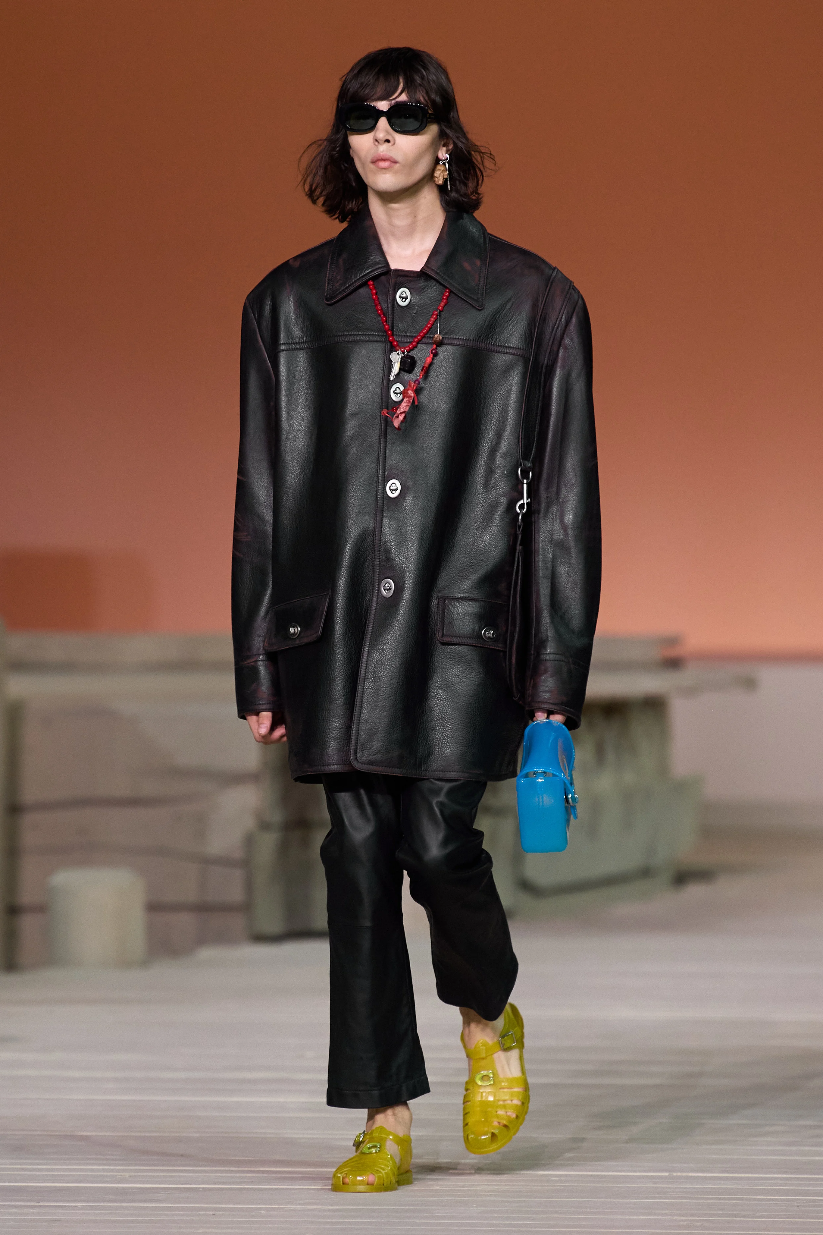 A model wearing a matching set in leather, a big 2023 spring trend, on the Coach runway.